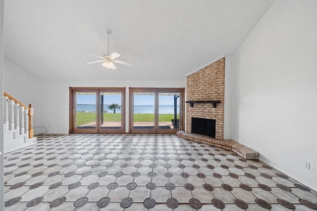unfurnished living room with vaulted ceiling, a ceiling fan, healthy amount of natural light, a fireplace, and baseboards