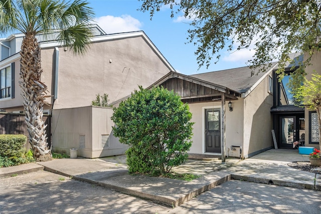 view of front of house with stucco siding, fence, and a patio area