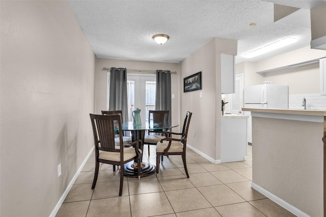 4006 Blalock Rd, Houston, TX 77080 - dining area featuring light tile patterned flooring, a textured ceiling, and baseboards