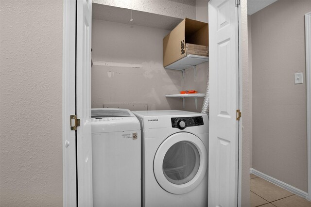 4006 Blalock Rd, Houston, TX 77080 - clothes washing area featuring laundry area, a textured wall, light tile patterned floors, washing machine and clothes dryer, and baseboards