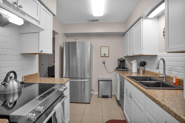 4006 Blalock Rd, Houston, TX 77080 - kitchen with a sink, under cabinet range hood, stainless steel appliances, white cabinetry, and visible vents