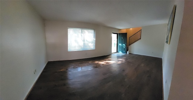 unfurnished room featuring wood finished floors and stairway