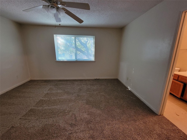 empty room with ceiling fan, light colored carpet, and a textured ceiling