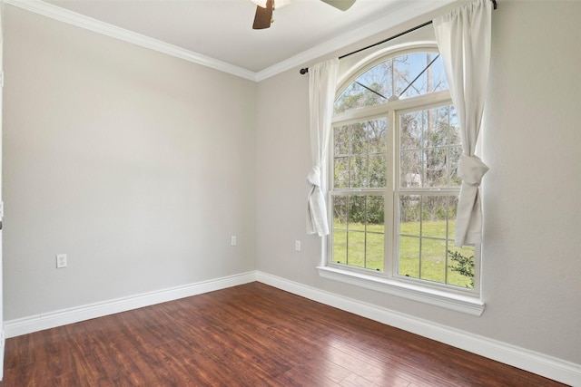 spare room featuring ornamental molding, ceiling fan, baseboards, and dark wood finished floors