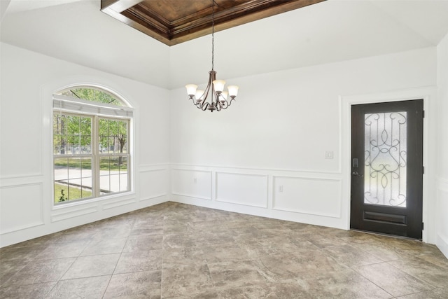 spare room featuring a decorative wall, stone finish flooring, a wainscoted wall, wooden ceiling, and a notable chandelier
