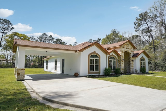 mediterranean / spanish home with a front yard, driveway, and stucco siding