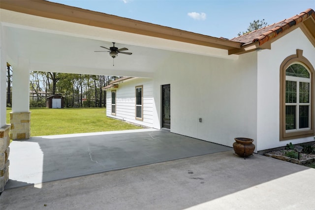 view of patio / terrace featuring ceiling fan, an outdoor structure, and a storage unit