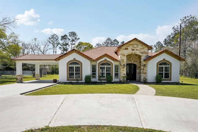 mediterranean / spanish-style home featuring a front yard, fence, and stucco siding