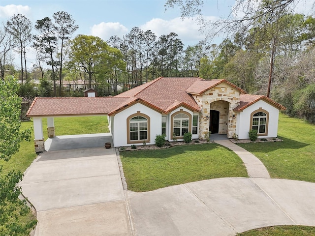 mediterranean / spanish home featuring driveway, stucco siding, stone siding, and a front lawn