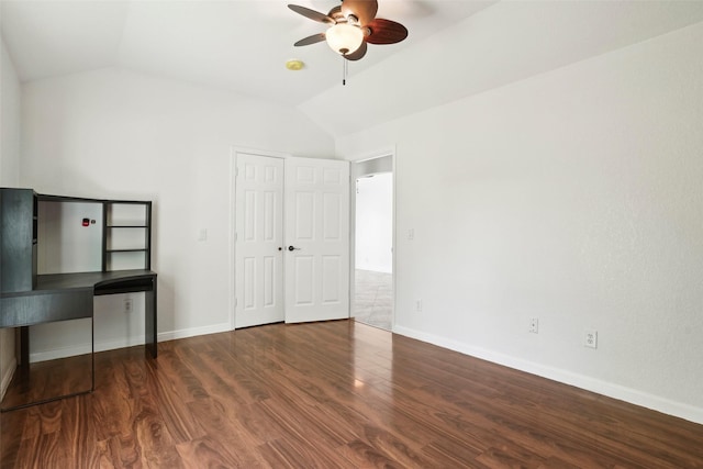 unfurnished bedroom with wood finished floors, baseboards, and lofted ceiling