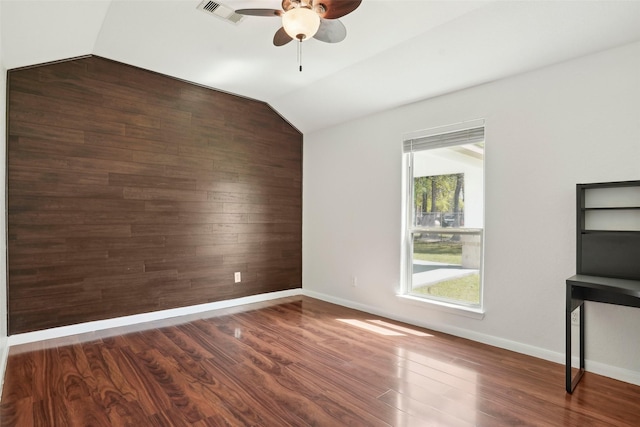 spare room with visible vents, vaulted ceiling, a ceiling fan, and wood finished floors