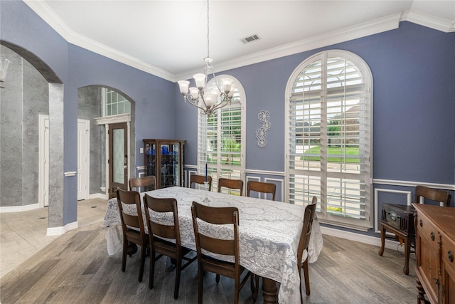 98 Victoria Dr W, Montgomery, TX 77356 - dining room featuring arched walkways, a wainscoted wall, visible vents, and an inviting chandelier