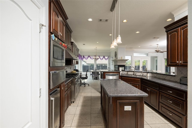 98 Victoria Dr W, Montgomery, TX 77356 - kitchen featuring a warming drawer, decorative light fixtures, a sink, a ceiling fan, and appliances with stainless steel finishes