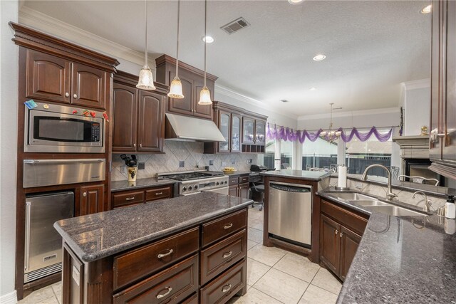 98 Victoria Dr W, Montgomery, TX 77356 - kitchen with a warming drawer, wine cooler, under cabinet range hood, visible vents, and appliances with stainless steel finishes