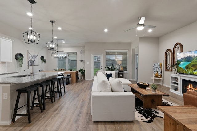 1144 Courteous Creek Dr, Montgomery, TX 77316 - living room featuring light wood finished floors, a ceiling fan, recessed lighting, baseboards, and a warm lit fireplace