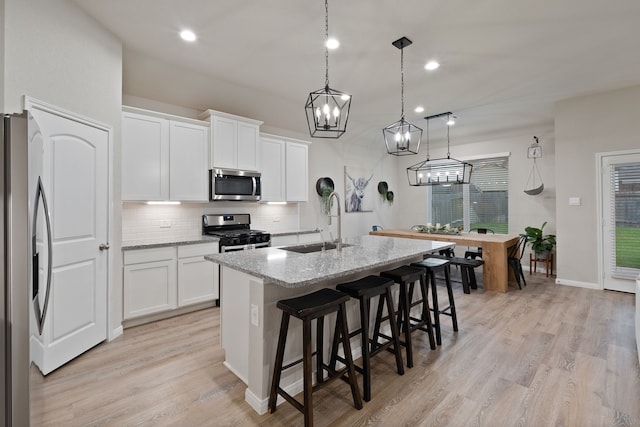 1144 Courteous Creek Dr, Montgomery, TX 77316 - kitchen featuring stainless steel appliances, a sink, tasteful backsplash, a breakfast bar area, and light stone countertops