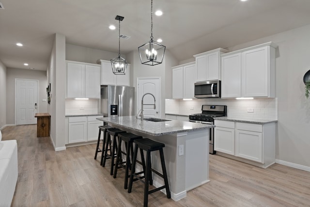 1144 Courteous Creek Dr, Montgomery, TX 77316 - kitchen with stainless steel appliances, a sink, a center island with sink, tasteful backsplash, and a breakfast bar