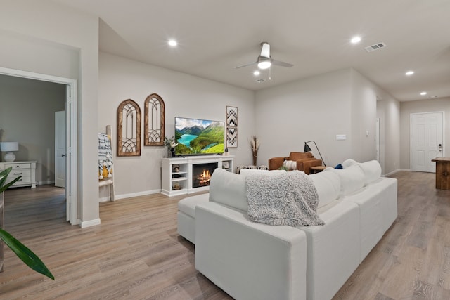 1144 Courteous Creek Dr, Montgomery, TX 77316 - living area featuring recessed lighting, light wood-type flooring, baseboards, a ceiling fan, and a warm lit fireplace