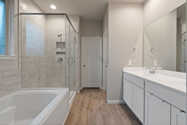 1144 Courteous Creek Dr, Montgomery, TX 77316 - bathroom with wood finished floors, a garden tub, a stall shower, double vanity, and baseboards