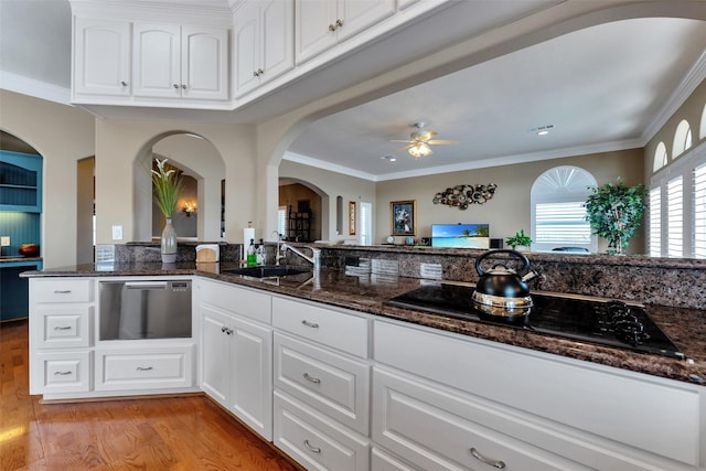 1306 Outrigger, Tiki Island, TX 77554 - kitchen featuring a sink, light wood-style flooring, black electric cooktop, dark stone countertops, and crown molding