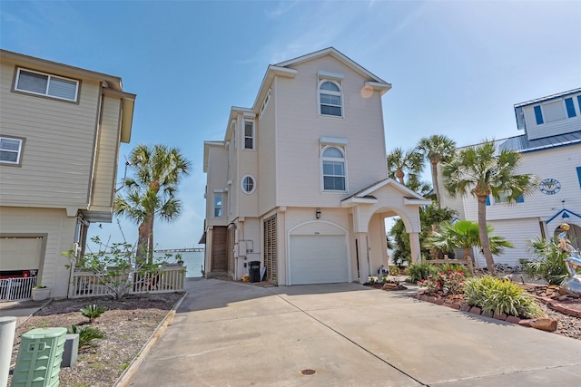1306 Outrigger, Tiki Island, TX 77554 - coastal home featuring driveway, an attached garage, and central air condition unit