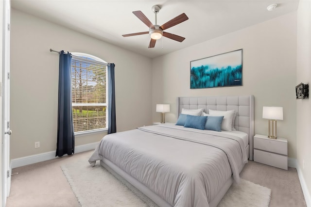 bedroom with ceiling fan, light colored carpet, and baseboards