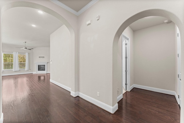 interior space featuring crown molding, baseboards, and dark wood-style floors