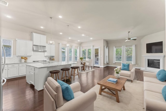 living room with dark wood-style flooring, visible vents, recessed lighting, and a ceiling fan