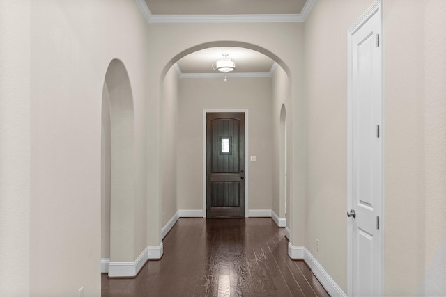 interior space featuring arched walkways, wood finished floors, baseboards, and ornamental molding