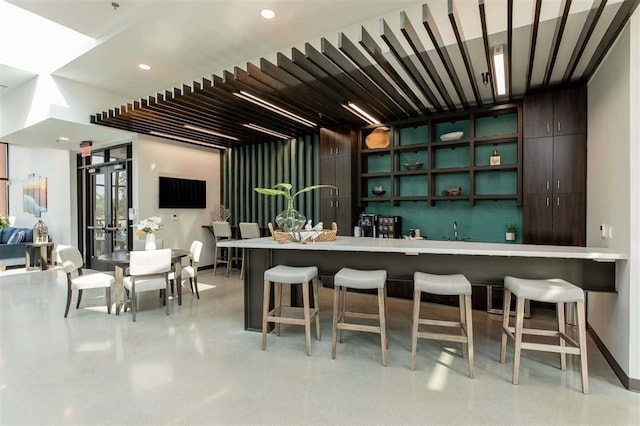 bar with baseboards and indoor wet bar