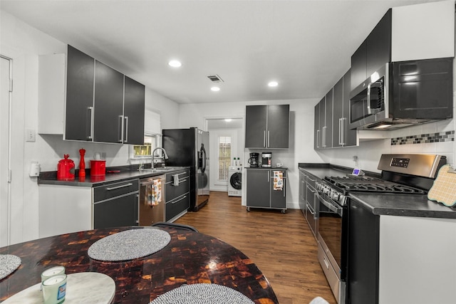 5808 Community Dr, Houston, TX 77005 - kitchen featuring washer / clothes dryer, dark countertops, appliances with stainless steel finishes, and dark cabinets