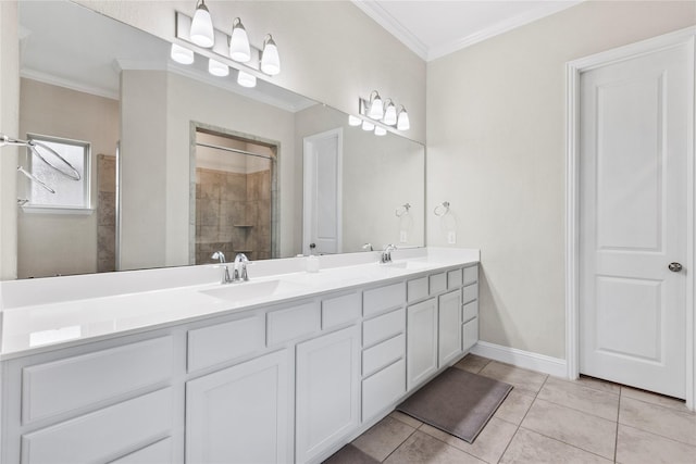 bathroom with tile patterned floors, a tile shower, a sink, and ornamental molding