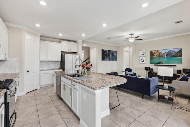 kitchen featuring ornamental molding, visible vents, appliances with stainless steel finishes, a sink, and open floor plan