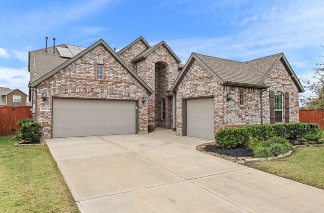 view of front of house with driveway, fence, a shingled roof, and a garage