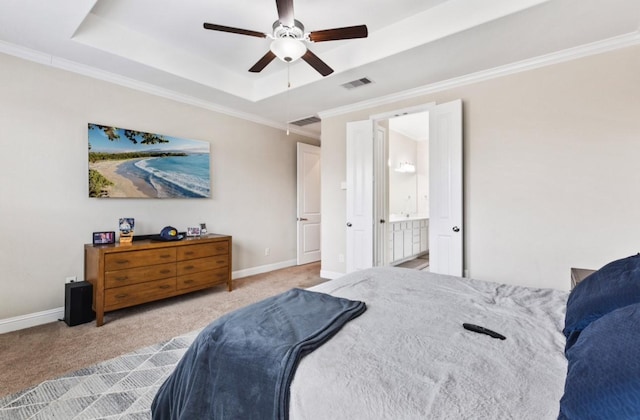 carpeted bedroom with ornamental molding, a tray ceiling, baseboards, and visible vents