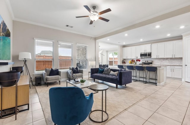 living room featuring recessed lighting, light tile patterned floors, crown molding, and a ceiling fan
