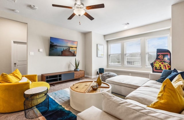 carpeted living room featuring visible vents, baseboards, and a ceiling fan