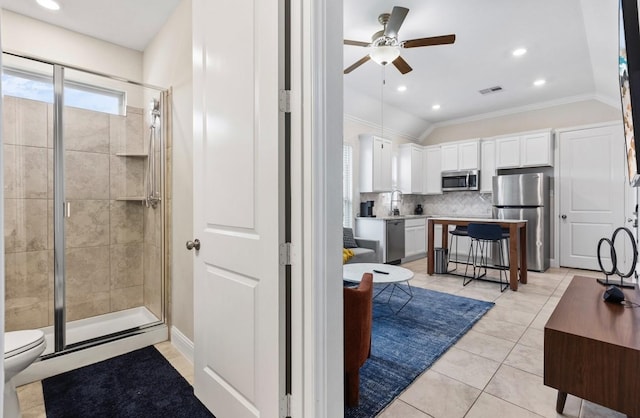 bathroom featuring tasteful backsplash, ceiling fan, visible vents, and a stall shower