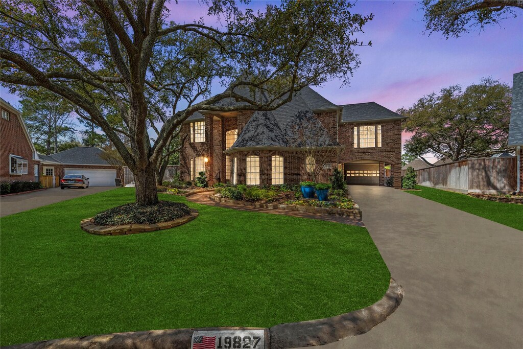 19827 Maple Chase Ln, Houston, TX 77094 - traditional-style home with concrete driveway, brick siding, a garage, fence, and a lawn