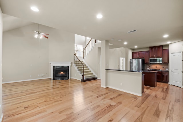 155 Pronghorn Pl, Montgomery, TX 77316 - kitchen with visible vents, a premium fireplace, dark countertops, appliances with stainless steel finishes, and open floor plan