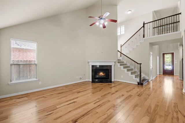 155 Pronghorn Pl, Montgomery, TX 77316 - unfurnished living room with stairway, a healthy amount of sunlight, ceiling fan, and light wood-type flooring