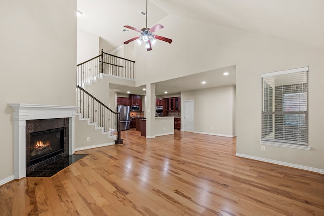 155 Pronghorn Pl, Montgomery, TX 77316 - unfurnished living room with a premium fireplace, light wood finished floors, baseboards, stairs, and a ceiling fan