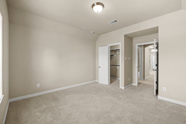 155 Pronghorn Pl, Montgomery, TX 77316 - unfurnished bedroom with visible vents, baseboards, light carpet, vaulted ceiling, and a walk in closet