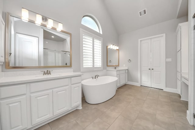 bathroom with vaulted ceiling, a shower stall, a sink, visible vents, and two vanities