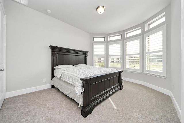 bedroom featuring baseboards and light colored carpet