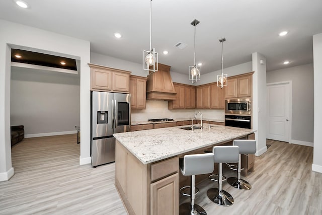 10015 Crescent Wood Dr, Missouri City, TX 77459 - kitchen featuring recessed lighting, premium range hood, stainless steel appliances, a center island with sink, and a sink