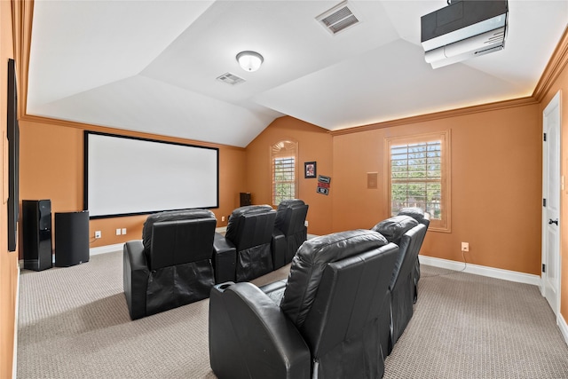 cinema room featuring baseboards, lofted ceiling, visible vents, and light carpet