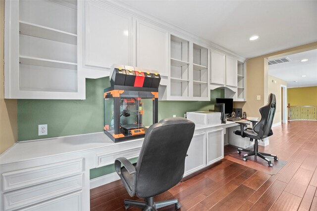 office space with dark wood finished floors, visible vents, and built in study area