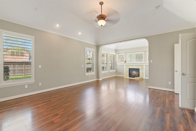 17310 Calico Peak Way, Cypress, TX 77433 - unfurnished living room with a ceiling fan, dark wood-style flooring, arched walkways, a tiled fireplace, and baseboards