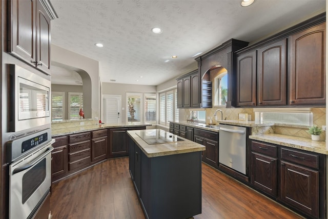 17310 Calico Peak Way, Cypress, TX 77433 - kitchen featuring appliances with stainless steel finishes, arched walkways, healthy amount of natural light, a sink, and recessed lighting